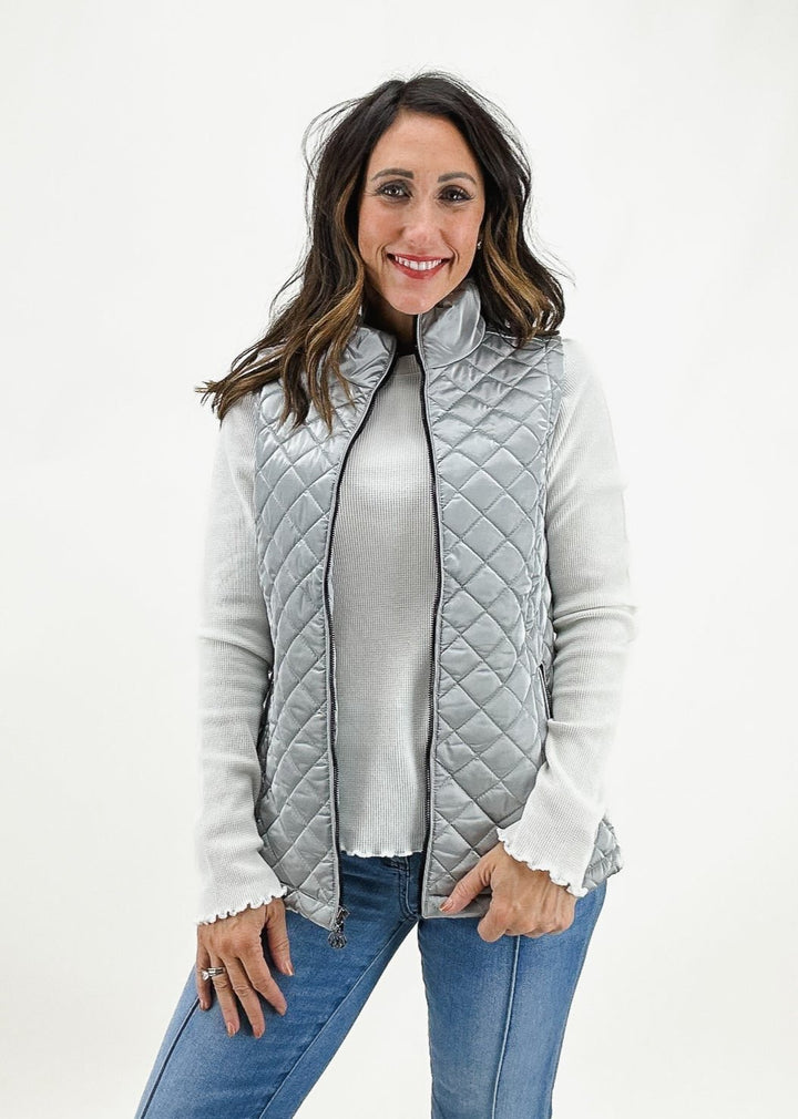 women's silver quilted puffer vest layered over ribbed long sleeve white tee