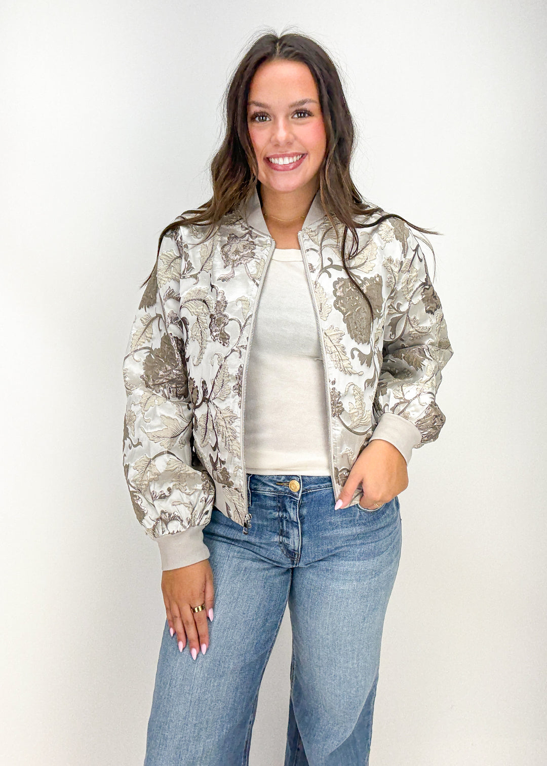 Woman wearing a floral bomber jacket and jeans