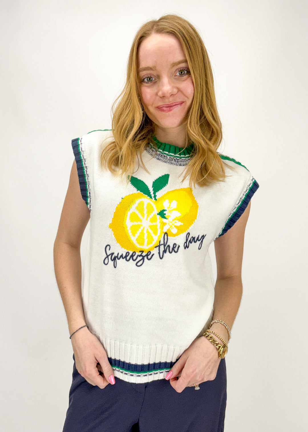 Woman wearing a sleeveless sweater with a lemon design and text on a white background