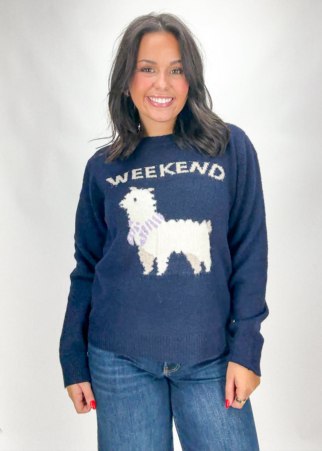 Woman wearing a navy sweater with a llama graphic and 'Weekend' text on a white background