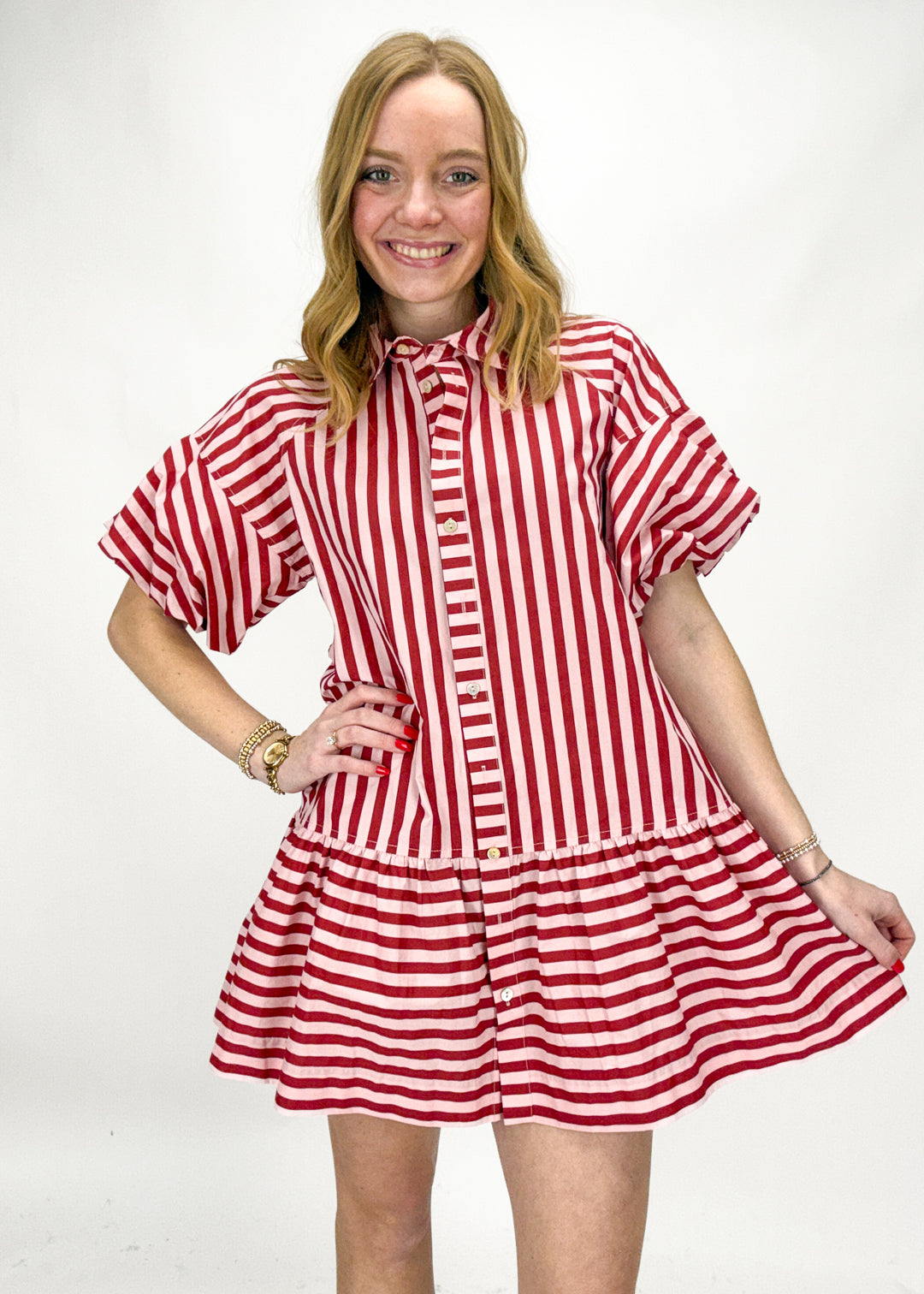 Woman wearing a red and pink striped dress on a white background