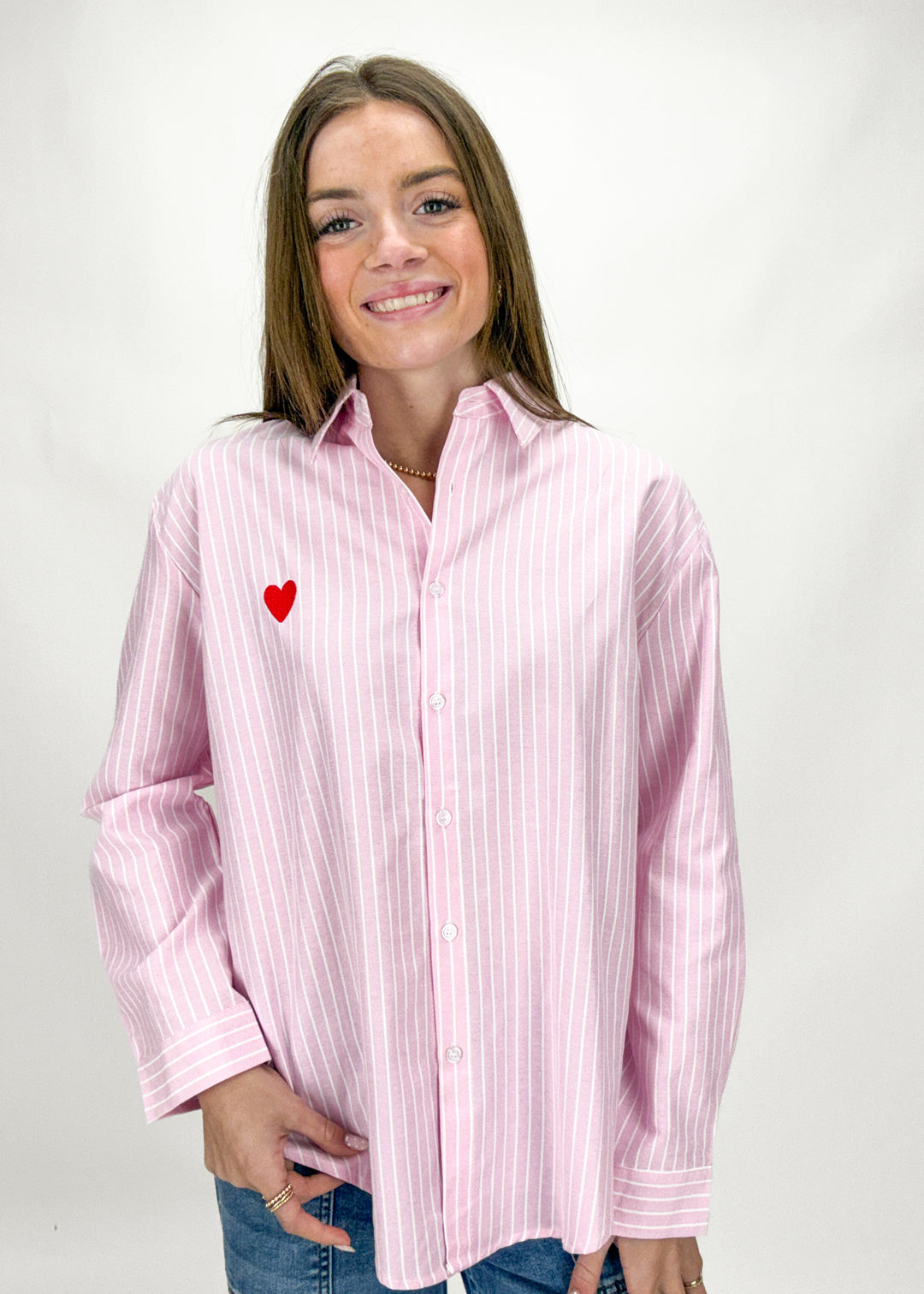 Woman wearing a pink striped shirt with a red heart on a white background