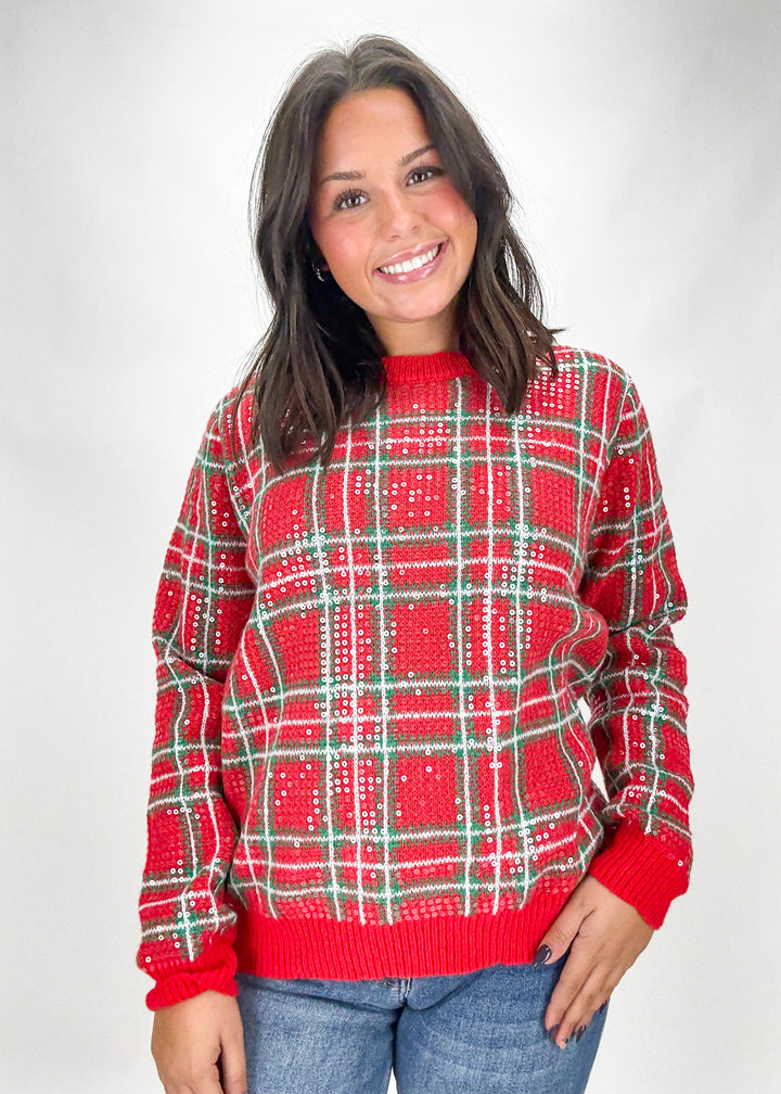 Woman wearing a red plaid sweater on a white background