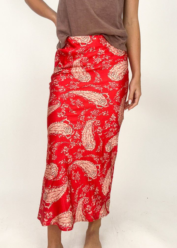 woman wearing red and peach paisley slip midi skirt