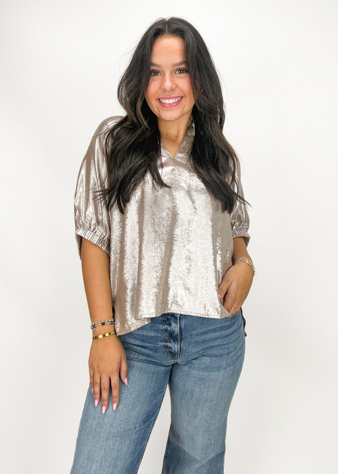 Woman wearing a metallic top and jeans 
