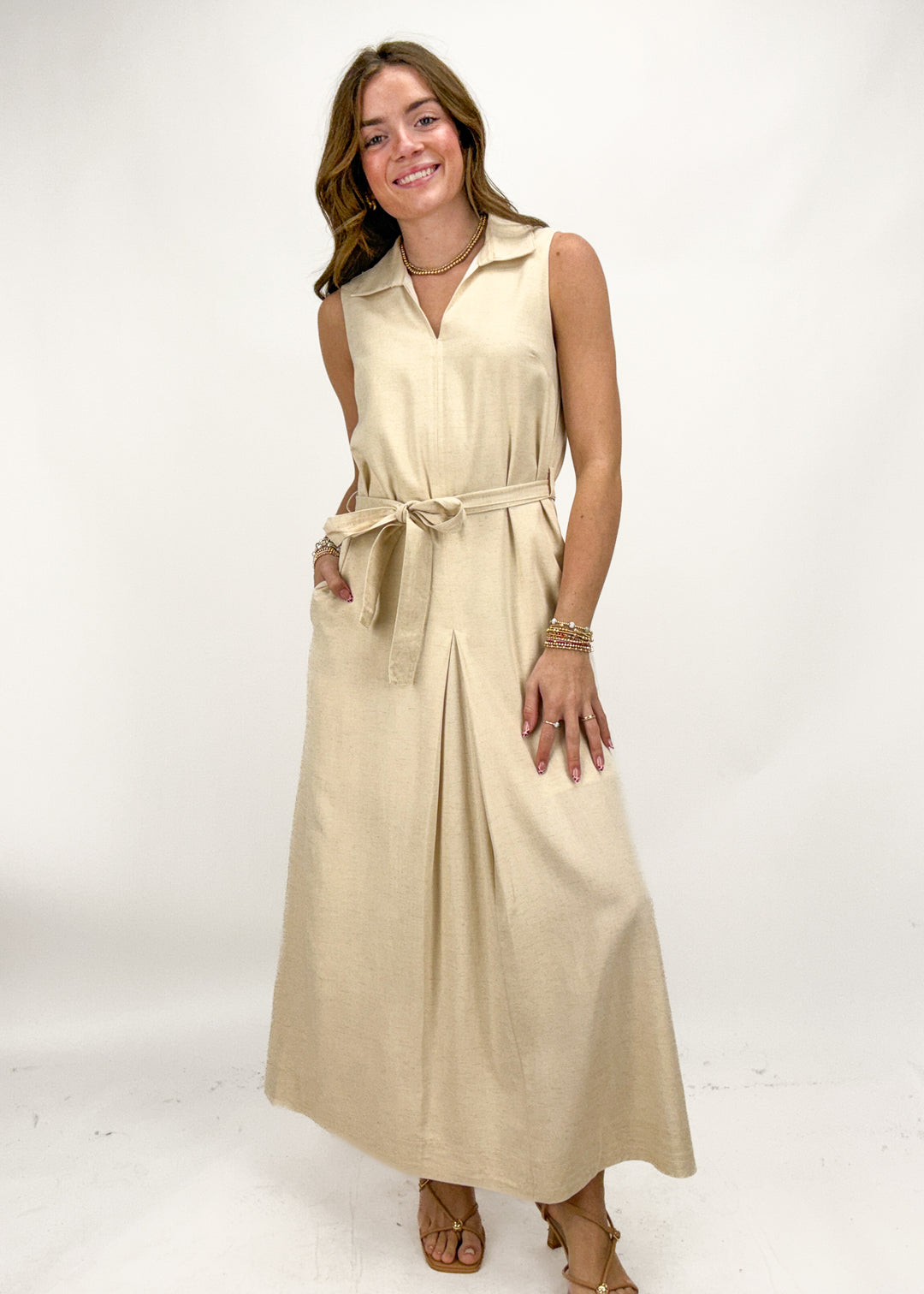 Woman wearing a beige sleeveless dress on a white background
