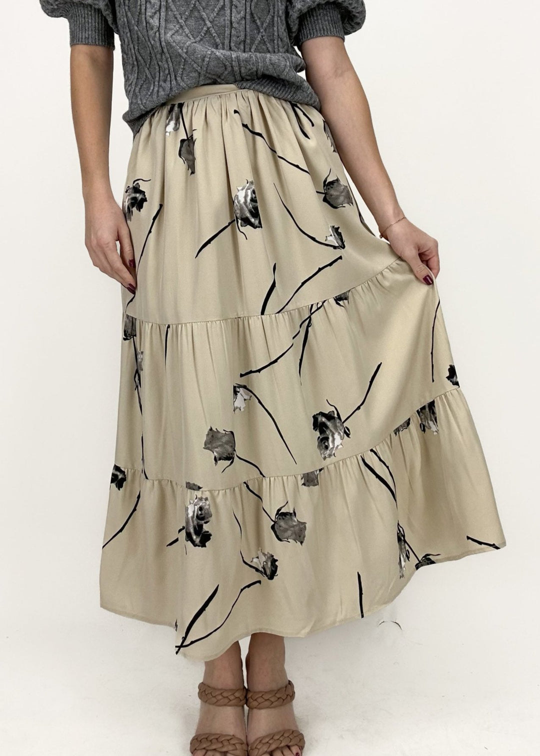 tan tiered maxi skirt with black floral rose print styled with grey short puff sleeve sweater top and tan braided two strap heels