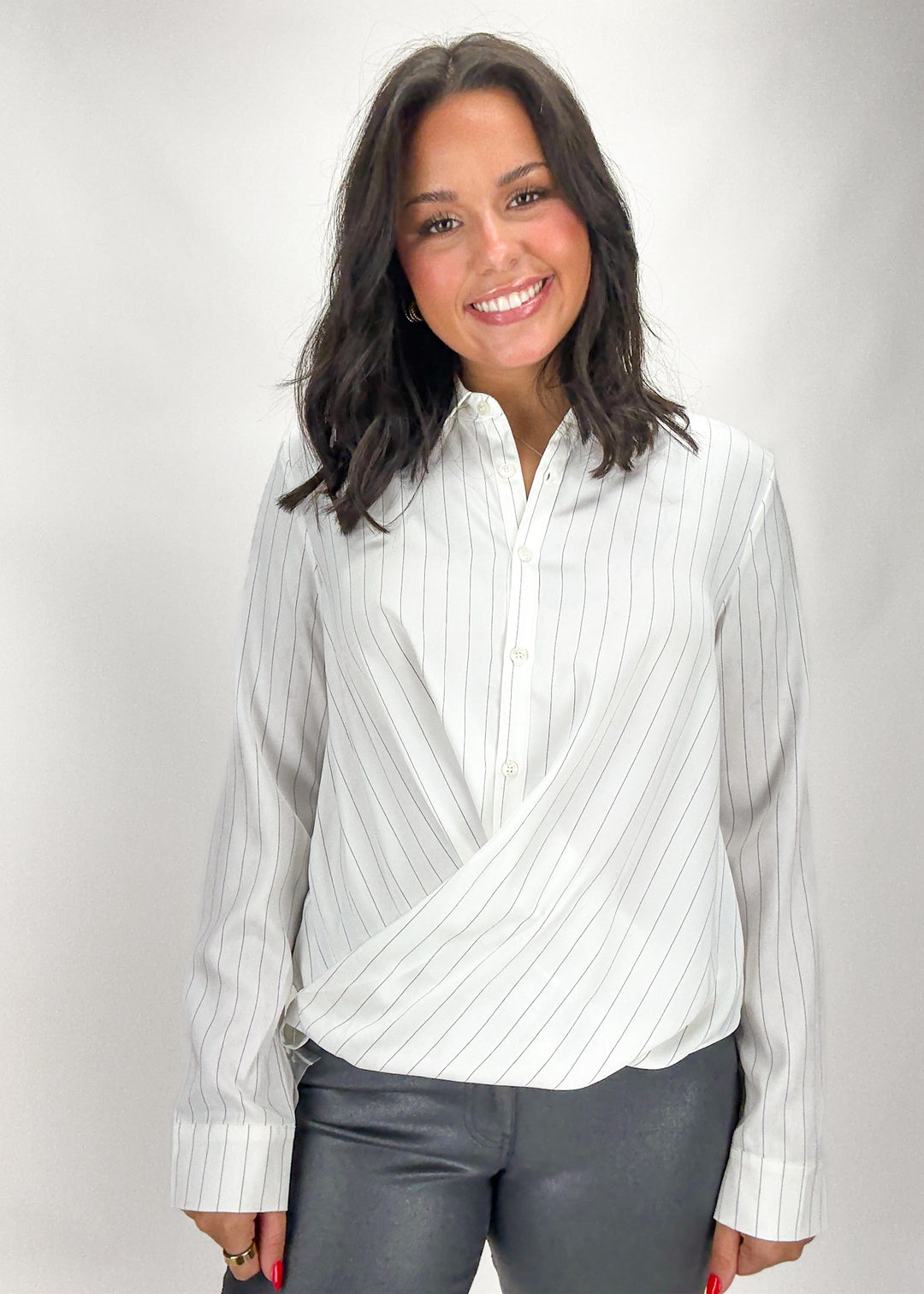 Woman wearing a white striped shirt with a gray background
