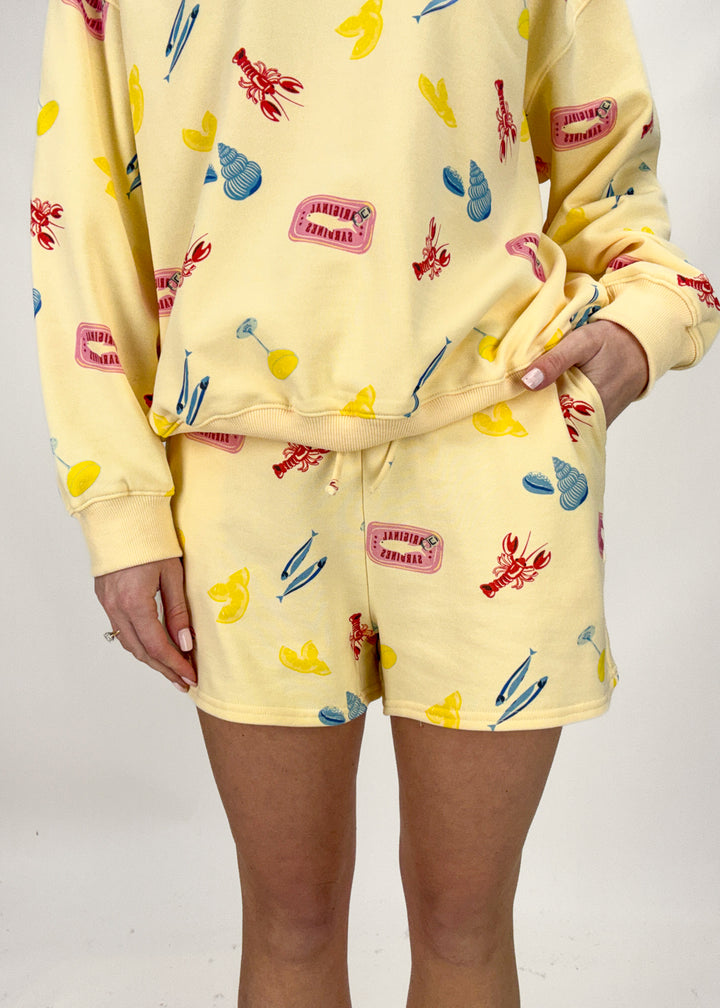 Person wearing a yellow pajama set with colorful patterns on a plain background