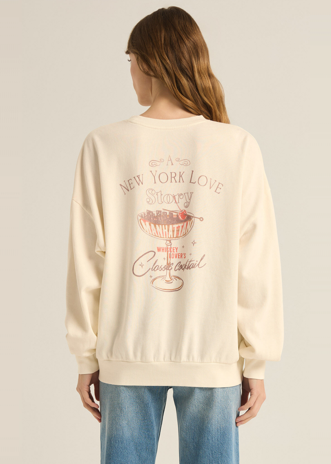 cream women's sweatshirt with Manhattan cocktail love story graphic on back